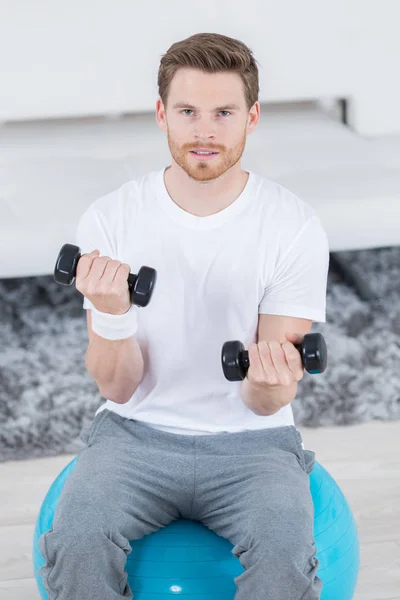 Schöner und sportlicher Typ, der die Hantel hebt — Stockfoto