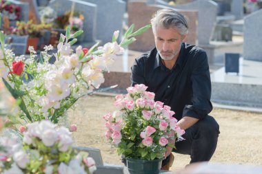 Man in black knelt at grave clipart