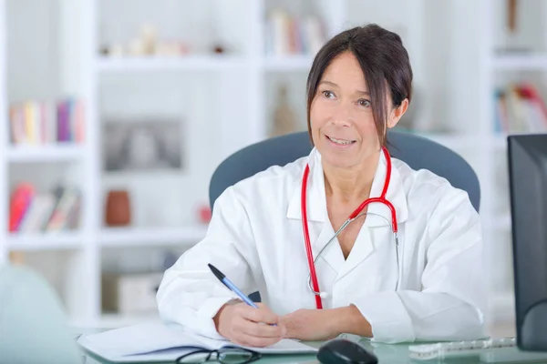 Médico feminino que escreve prescrição para paciente — Fotografia de Stock