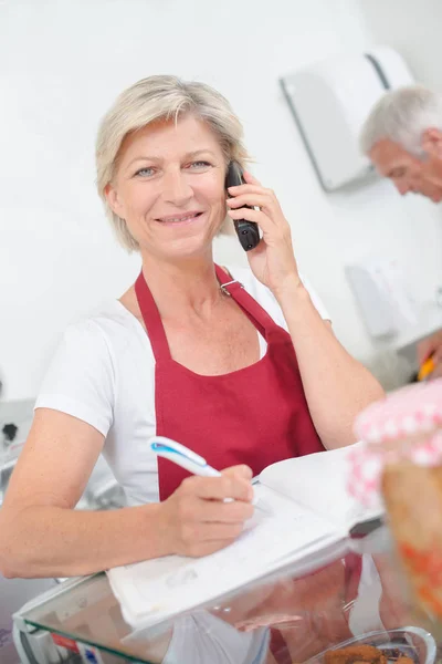 Señora en el teléfono con una libreta de registro — Foto de Stock