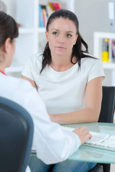 Médico masculino conversando com paciente em consultório médico — Fotografia de Stock