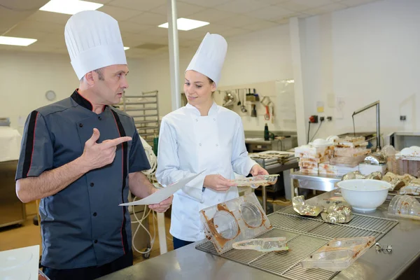 Portret van twee chef-koks in uniform van de kok in de keuken — Stockfoto