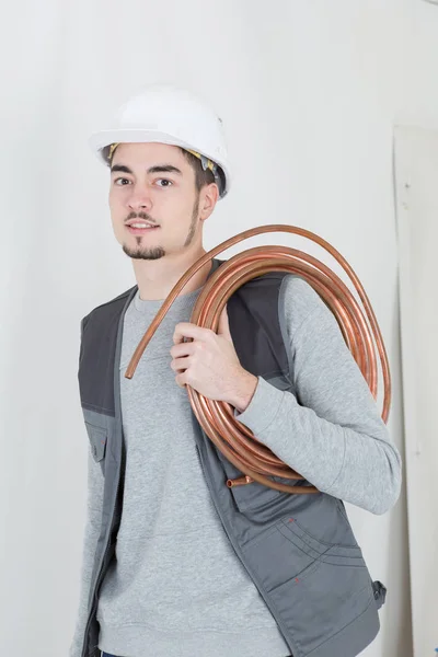 Portrait de beau plombier avec clé réglable et tuyau — Photo