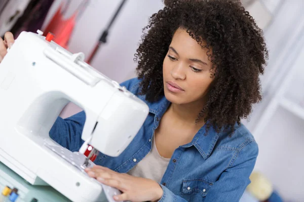 年轻女子缝纫织物上缝纫机 — 图库照片