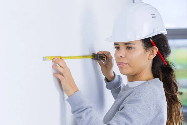 Donna costruttore misurare il muro — Foto Stock