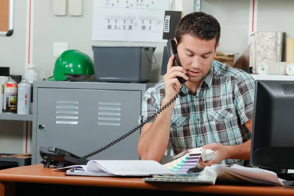 Mannen på telefon tittar på färgkartor — Stockfoto