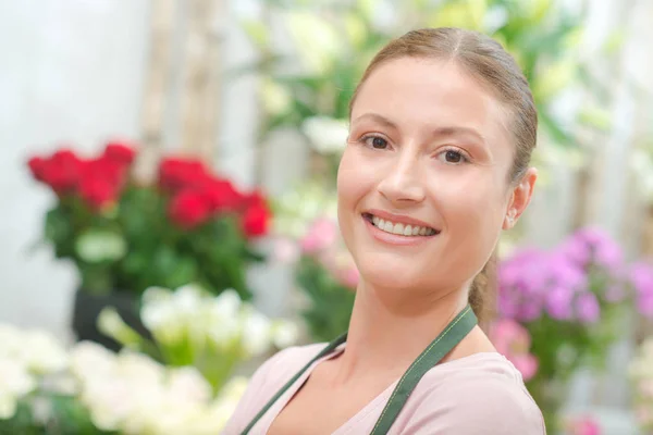 Sonriente florista joven y delantal — Foto de Stock