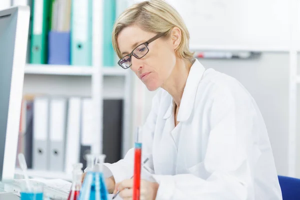 Científica femenina que escribe informe sobre experimentos científicos — Foto de Stock