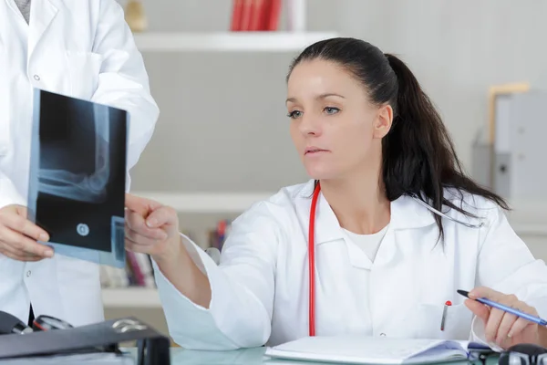 Лікар дивиться рентгенівське зображення руки — стокове фото