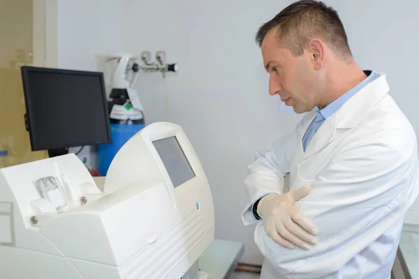 Médico mirando el equipo — Foto de Stock