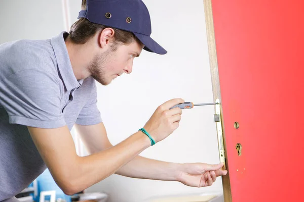 Reparador fixando maçaneta da porta — Fotografia de Stock
