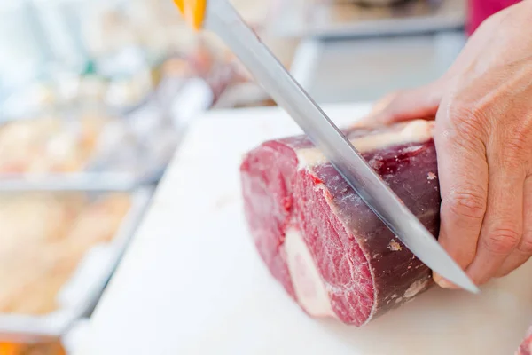 Carniceiro cortando carne bovina e abstrato — Fotografia de Stock