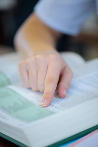 Fechar de dedo indicador em texto de livro — Fotografia de Stock