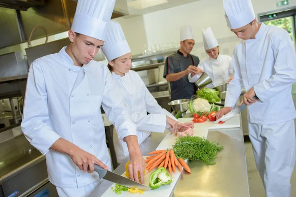 Equipe de chefs preparando legumes — Fotografia de Stock