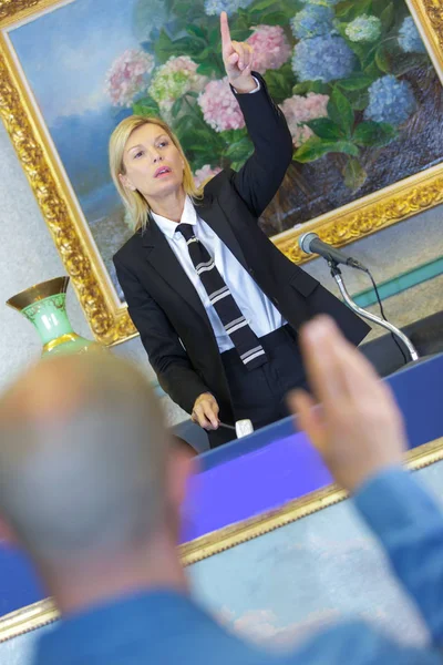 Kvinnliga auktionsutropare under försäljning man budgivning i förgrunden — Stockfoto