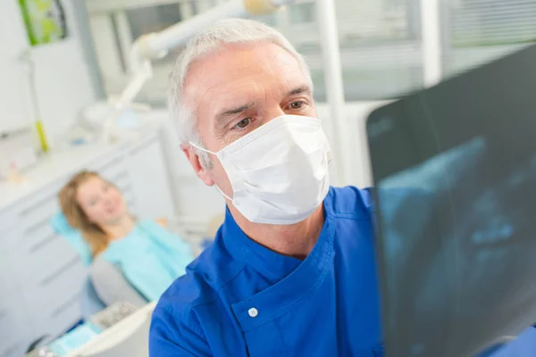 Οδοντίατρος κοιτάζοντας μια ακτινογραφία — Φωτογραφία Αρχείου