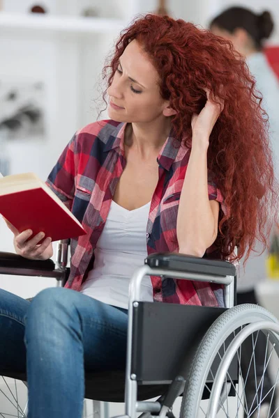 Disabili e disabili giovane donna disabile sulla sedia a rotelle legge libro — Foto Stock
