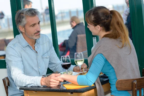 Couple holding hands across restaurant table — Stock Photo, Image