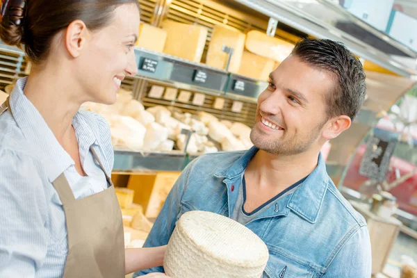 Shop assistant serving cheese Royalty Free Stock Photos