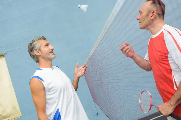 Man kastat badmintonbollen över netto till motståndare — Stockfoto