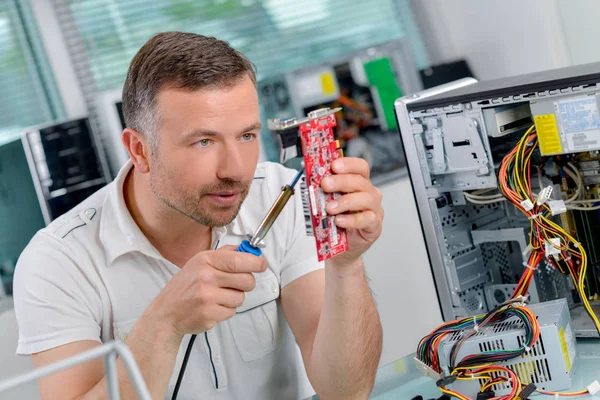 Hombre que fija la computadora y de mediana edad — Foto de Stock