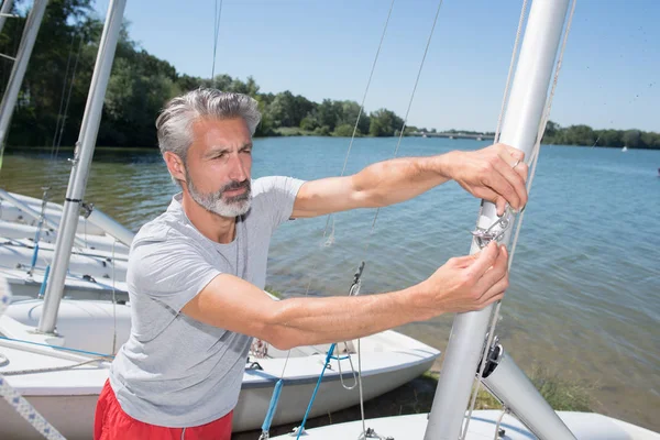 Atraente homem de meia-idade preparando veleiro esporte — Fotografia de Stock