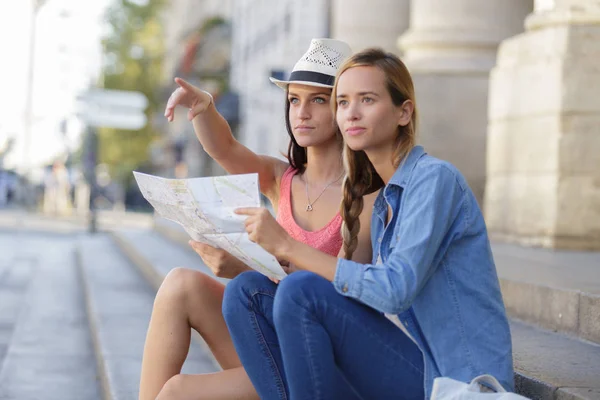 Perso e confuso ragazza amici in cerca di indicazioni sulla mappa — Foto Stock