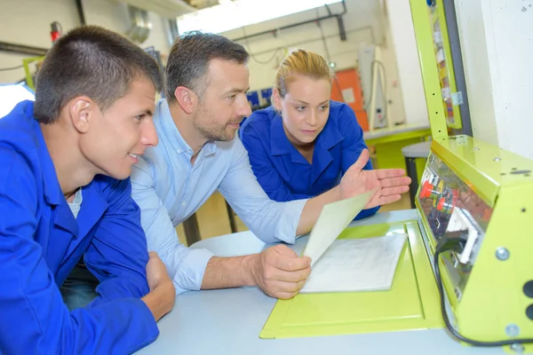 Mensen kijken naar technische machine — Stockfoto