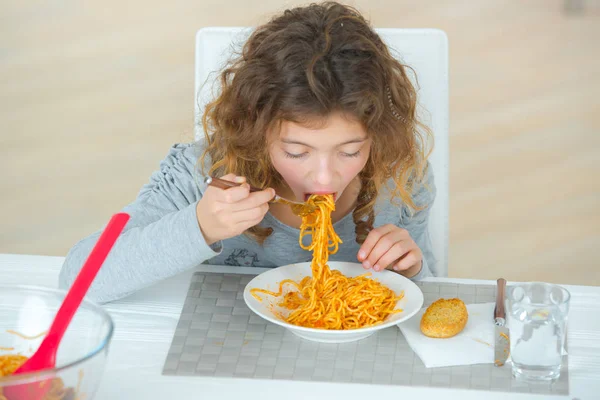 Ребенок ест спагетти и ребенок — стоковое фото