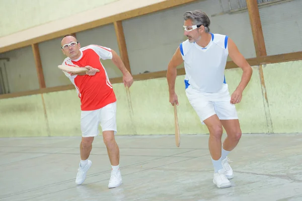 Homens jogando pala e esporte — Fotografia de Stock