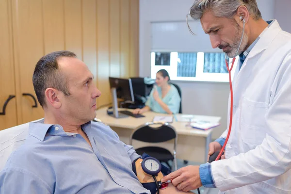 Doktor s pacienty s krevní tlak — Stock fotografie