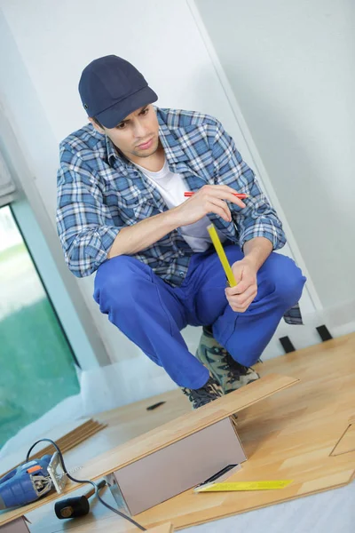 Installing laminate flooring fitting the next piece — Stock Photo, Image