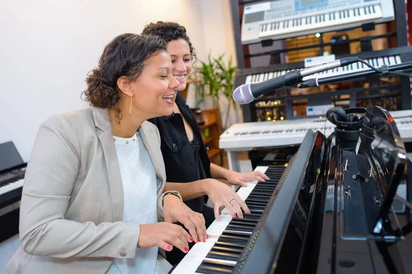 Mulheres tocando dueto no piano e cantando — Fotografia de Stock