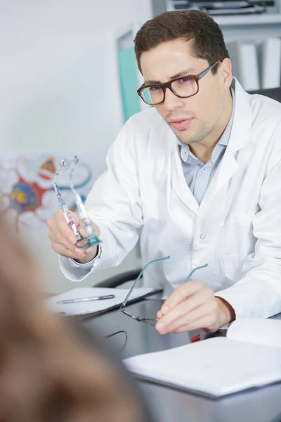 Jong ervaren oogarts praten met vrouwelijke patiënt — Stockfoto