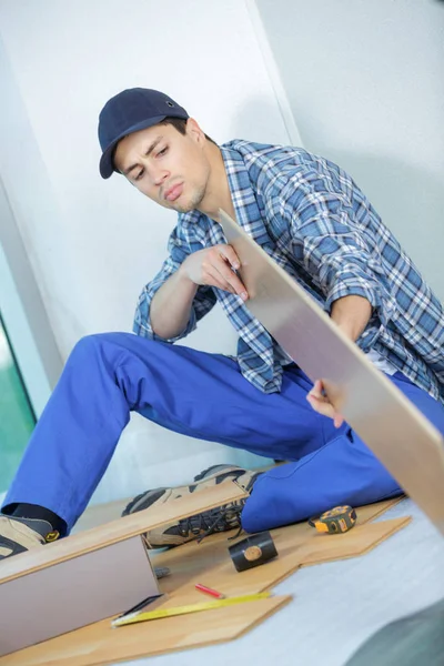 Dělník montážní nové laminátové podlahy — Stock fotografie
