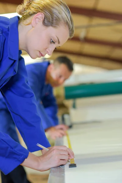 Werkneemster meten en markeren van materiaal — Stockfoto