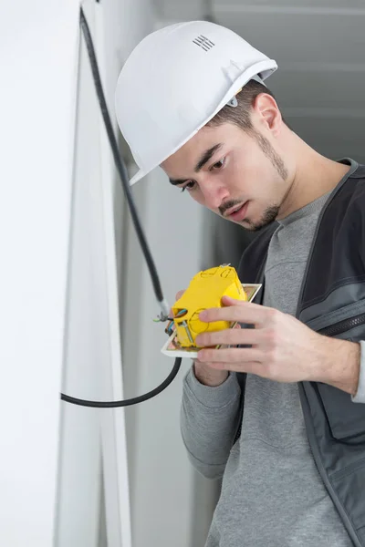 Handsome young electrician working at construction site — Stock Photo, Image