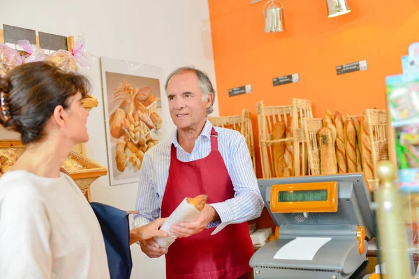 Mujer comprando baguette y delantal —  Fotos de Stock