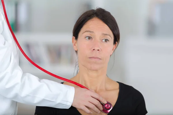 Ärztin untersucht Patientin mit Stethoskop — Stockfoto