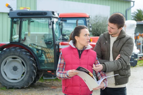 Venditrice convincere giovane agricoltore ad acquistare nuove macchine agricole — Foto Stock
