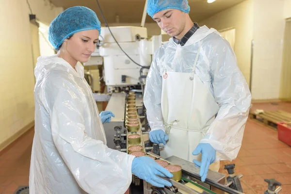 Operarios de fábrica supervisando la línea de producción — Foto de Stock