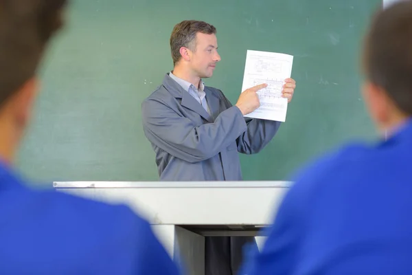 Lehrer zeigt auf Papierkram — Stockfoto