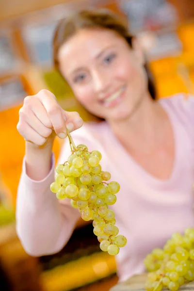 Woman holding grapes and adult — Stock Photo, Image