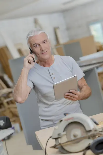Senior carpenter embracing technology — Stock Photo, Image