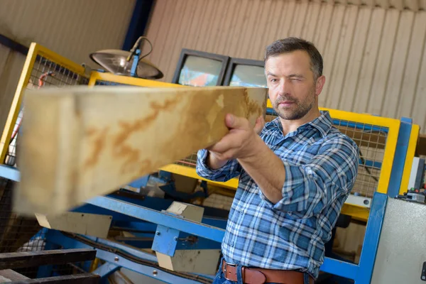 Sawmill employee working with wood tools and machinery — Stock Photo, Image