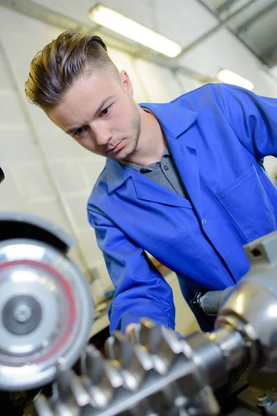 Apprentice engineer with metal gear — Stock Photo, Image