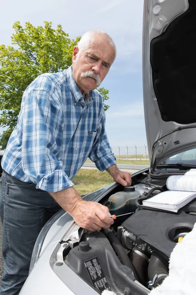 Älterer Mann wartet sein Auto zu Hause — Stockfoto