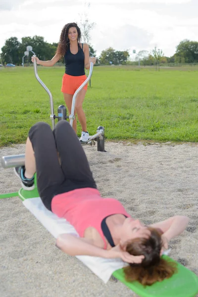 Mujeres que utilizan equipos de ejercicio en el parque — Foto de Stock