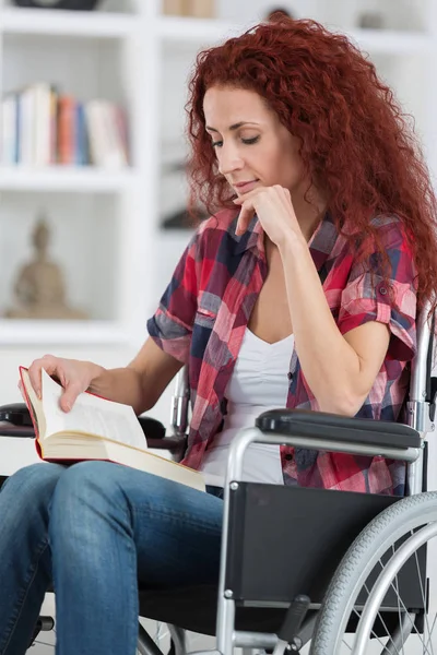 Discapacidad y minusvalía joven discapacitada en silla de ruedas lee libro —  Fotos de Stock