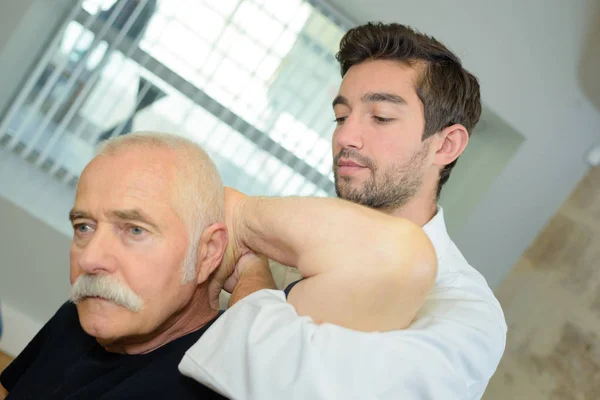 Therapist working on man s shoulder — Stock Photo, Image